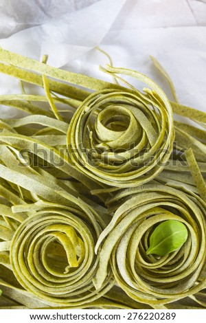 Raw homemade spinach pasta with spinach leaves