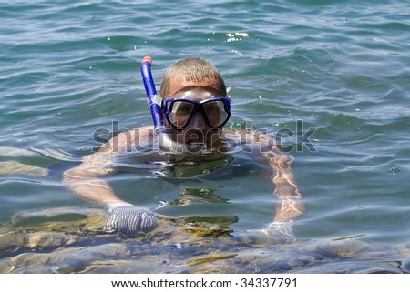 man in the water with fins mask and snorkel