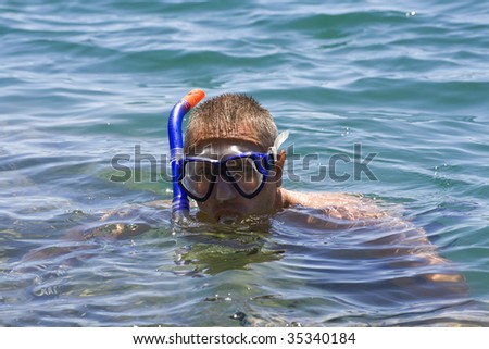 man in the water with fins mask and snorkel