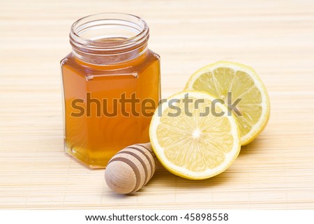 jar of honey, lemon and wooden drizzler