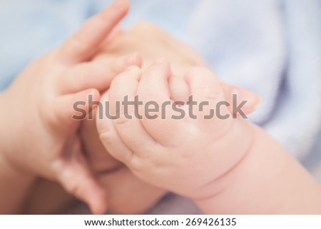 Baby taking his mother\'s hand