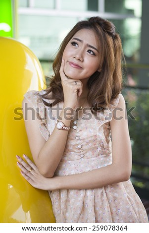 Asian woman thinking in looking pensive and happy in casual clothes i