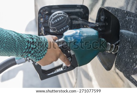 Hand refilling the car with fuel