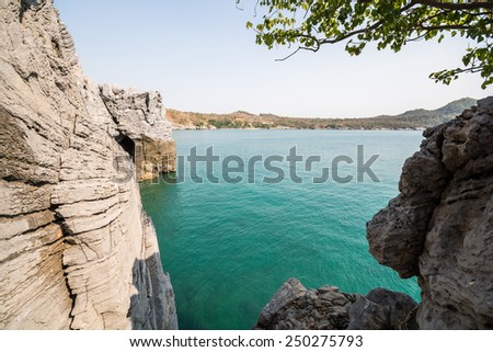 Rocky mountains and clear water at sunny day. \
Cliff and the clear sea.