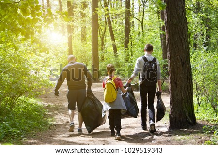 Recycle waste litter rubbish garbage trash junk clean training. Nature cleaning, volunteer ecology green concept. Young men and boys pick up spring forest at sunset . Environment plastic pollution
