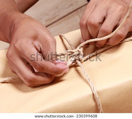 hand binding a rope in a gift