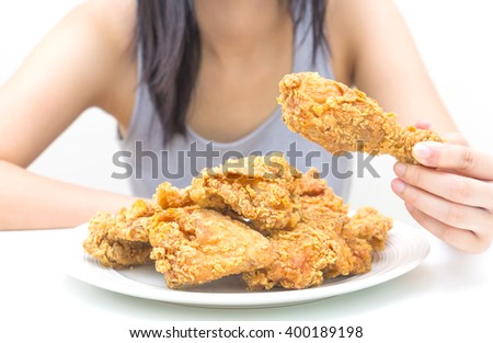 Woman holding and eatting fried chicken in white plate on white table