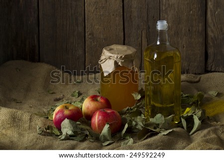 Apples with a jar of honey and a bottle of olive oil