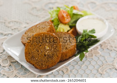Garlic rye toast with tomatoes, Chinese cabbage, lettuce, parsley and white sauce.