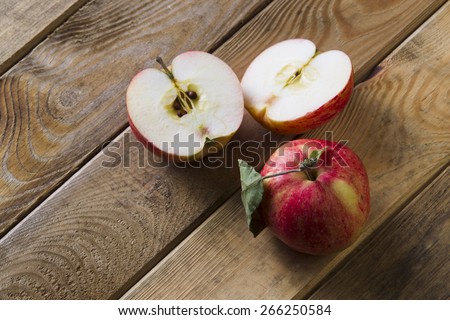 Whole and cut in half by red apples on the boards.