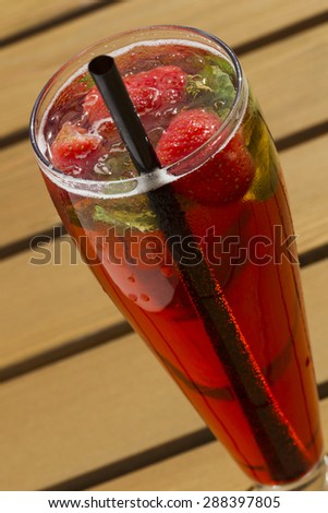 Cold lemonade with strawberries, mint and ice on the outdoor veranda summer day, sunlight.