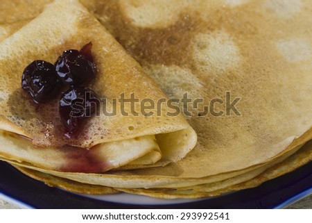 Plate with pancakes and jam on bank bels wooden boards lit studio lights, the view from the top.