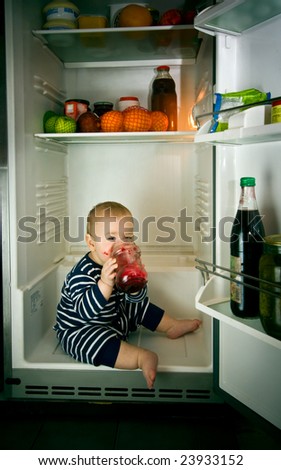 little boy eating jam in fridge