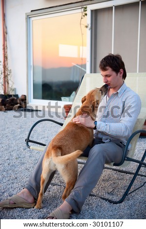 man playing with his dog in front of the house