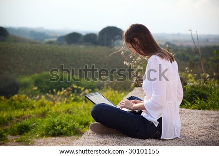 woman working with laptop in the countryside