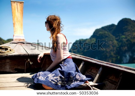 young woman sitting on a prow of a boat