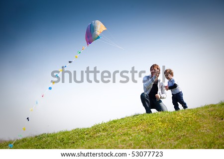 happy dad and son flying a kite together