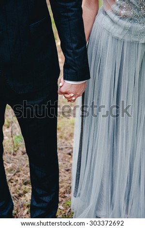Just married couple holding hands outdoors