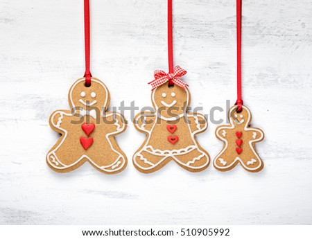 Happy Gingerbread man cookie family hanging on white background.