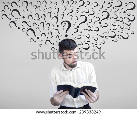 Human emotion facial expression.Surprised man reading a book. The guy has a lot of questions