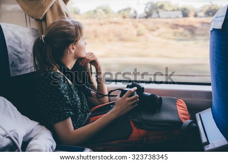 Girl tourist is looking out the window. fast train
