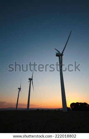 wind turbines in silhouette at sunset