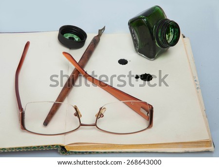Ink, glasses, pen and paper ready for writing