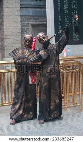 TIANJIN, CHINA - JUNE 25, 2013: two street artists in specific costums and with painted faces make performance on pedestrian street in Tianjin, China on 25th June, 2013