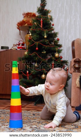 baby try to pull down colorful pyramid at home