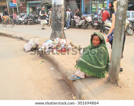 DELHI, INDIA - FEBRUARY 20, 2015: homeless woman waits somewhat near mosque in Delhi