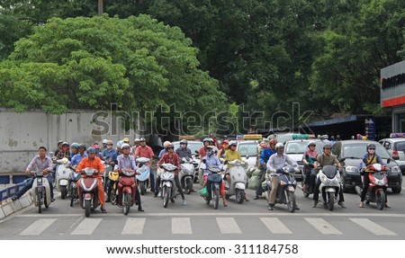 HANOI, VIETNAM - JUNE 2, 2015: people on crossroad are waiting the green signal of traffic light