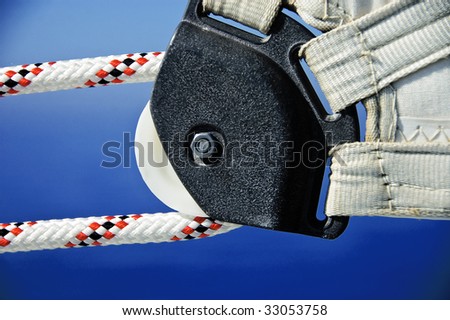 A photo of the corner of a yacht sail with rope and pulley