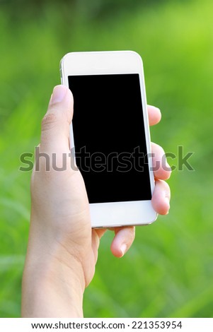 Hands holding smart phone with green background