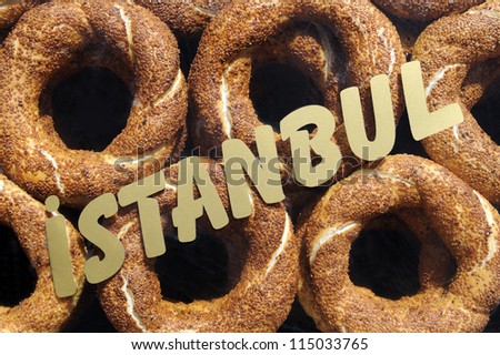Simit or Turkish bagel with sesame seed and istanbul sign in front, from closeup on street vendor trolley