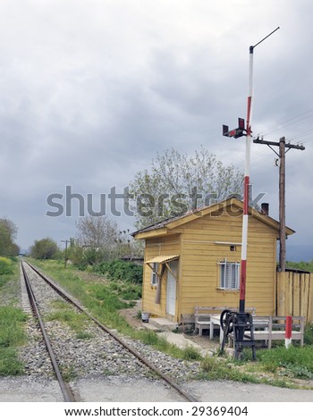 Old railway crossing with rail track, boom gate and guard\'s wooden shed