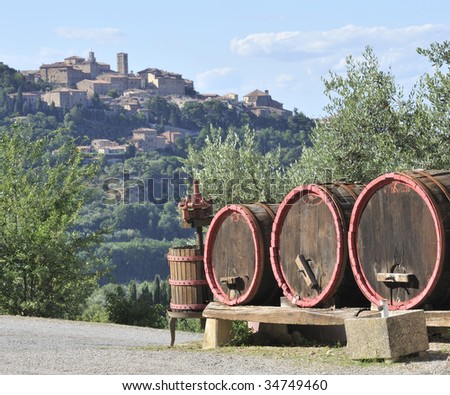 wine barrels and wine-making equipment with the town of Montepulciano in background, Italy