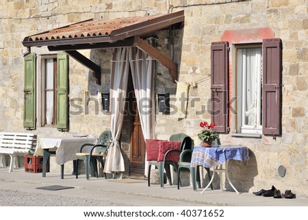 Table and chairs outside colorful Italian Villa