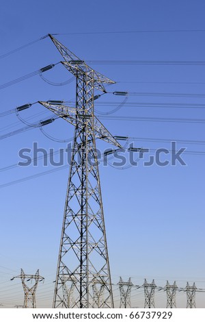 Electricity pylons against a clear blue sky