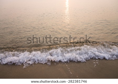 moving of wave to sand beach, sunset