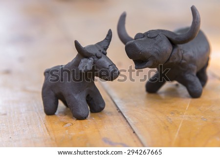 buffalo clay sculpture on wooden background in outdoor