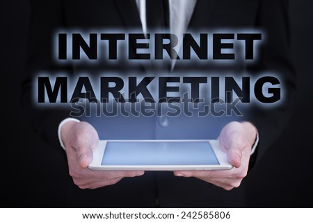 businessman holding a tablet with the projection of internet marketing concept. online marketing. digital marketing. SEO, SEM, SMM.