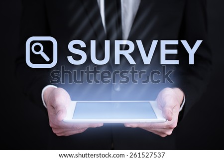 Businessman holding a tablet pc with survey text and icon on virtual screen . Internet concept. business concept.