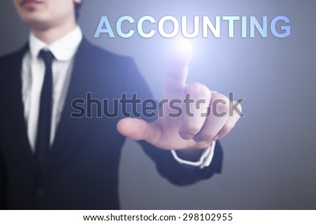 Businessman pressing button on touch screen interface and select Accounting. Business concept.