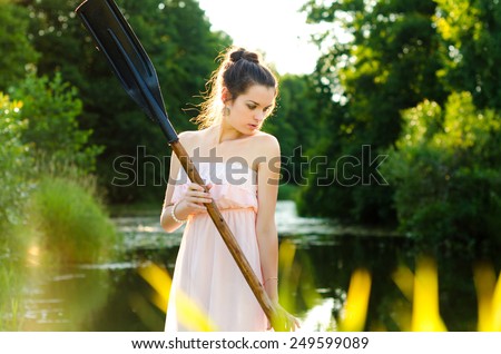The girl floats down the river with a paddle in his hand