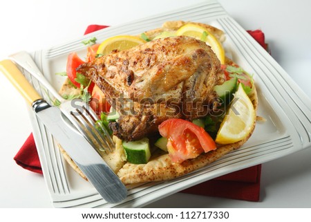 Mid-east style barbecue chicken.  very popular in Israel and other parts of the Middle East, the chicken is marinaded in lemon and spices and served  with coriander leaves on a salad and pitta bread