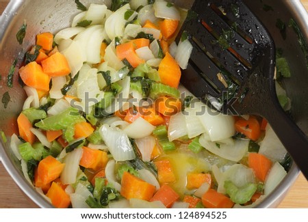 Frying onion, carrot and celery as part of the process of making a risotto
