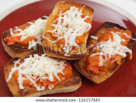 Pieces of toasted ciabatta topped with bruschetta and grated cheese and then grilled, a sort of quick mock pizza