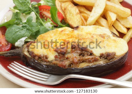 The Greek dish of aubergines stuffed with minced beef, onion and tomatoes, topped with bechamel sauce and cheese, served with a salad of rocket, lettuca and tomato, and french fried potato chips.
