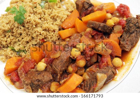 Plate of traditional Moroccan beef tagine with couscous, garnished with flat-leaf parsley