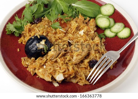 An authentic Saudi chicken kabsa (known in Qatar as majbous), garnished with raisins, parsley and almond flakes, on a serving bowl. Kabsa is a national staple for Saudi Arabia and the Arab Gulf States
